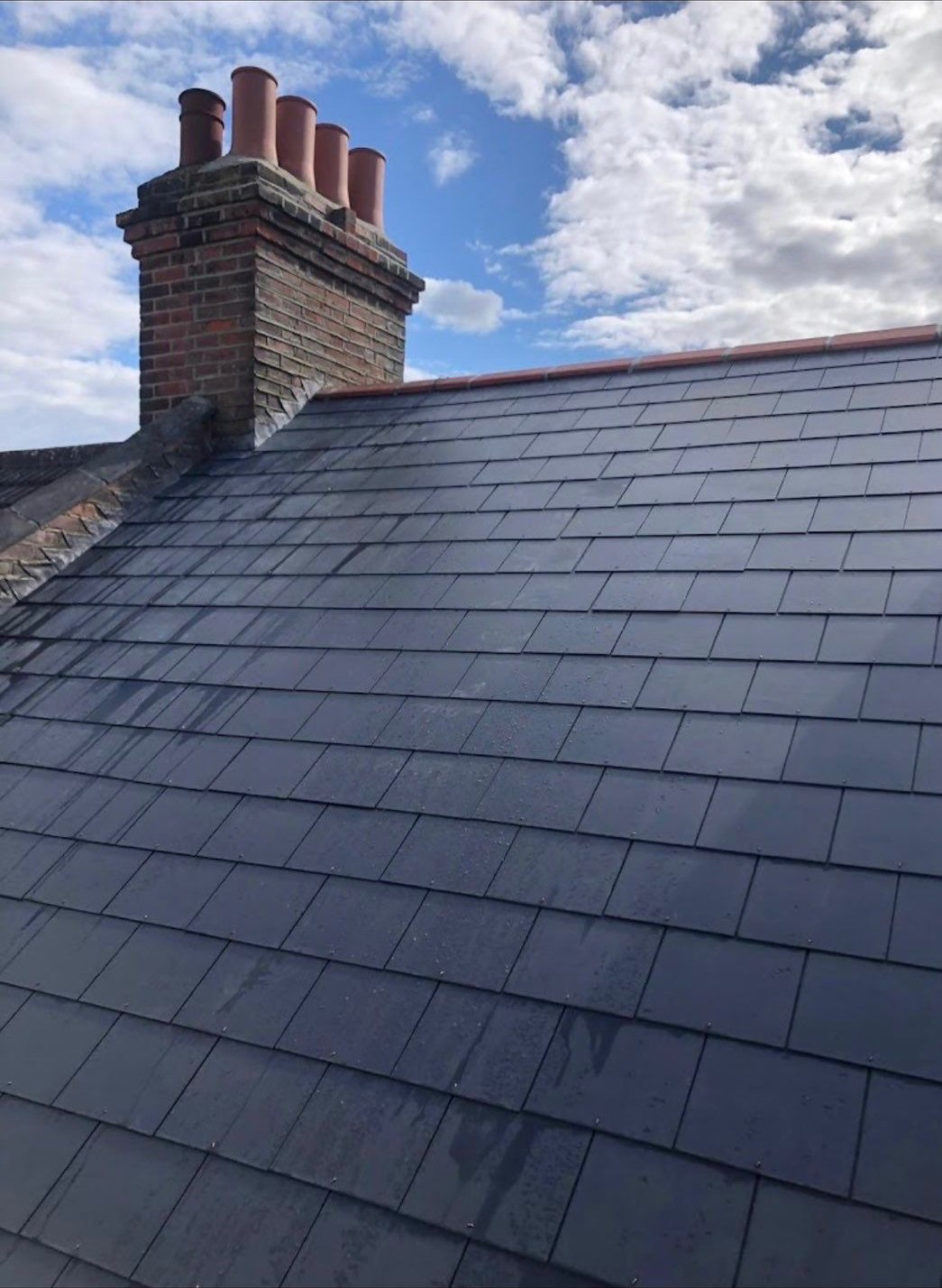 Finished slate roof around a chimney stack